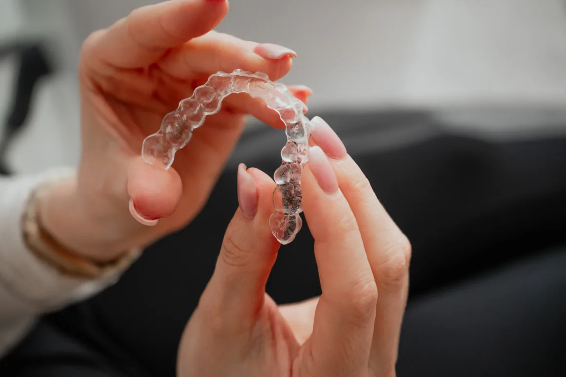 Hand hält eine transparente, herausnehmbare Zahnschiene