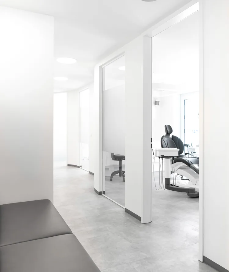 Blick vom Wartebereich durch die Glastür in einen Behandlungsraum der Praxis moderndentistry in Leipzig