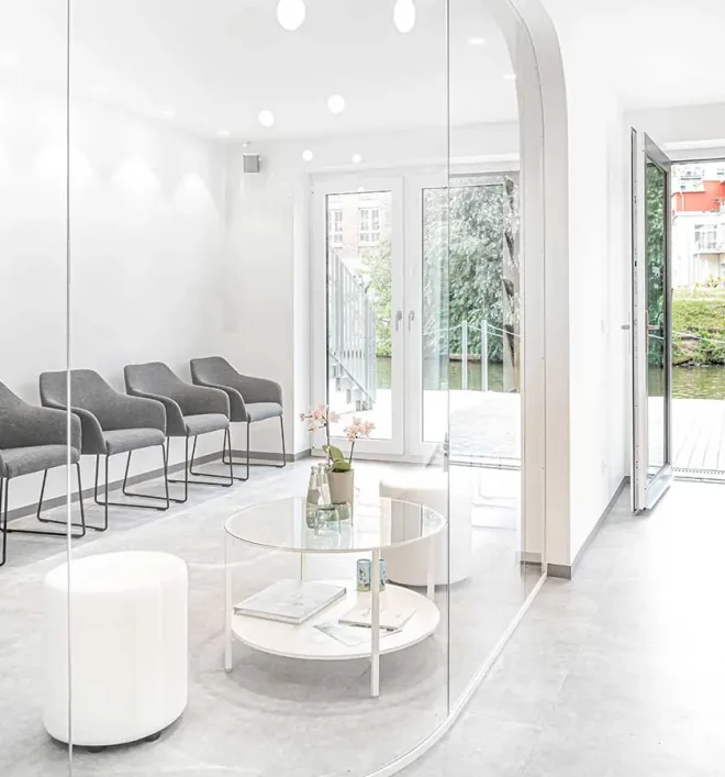 Wartebereich der Zahnarztpraxis moderndentistry mit Sitzgruppe und Blick ins Grüne